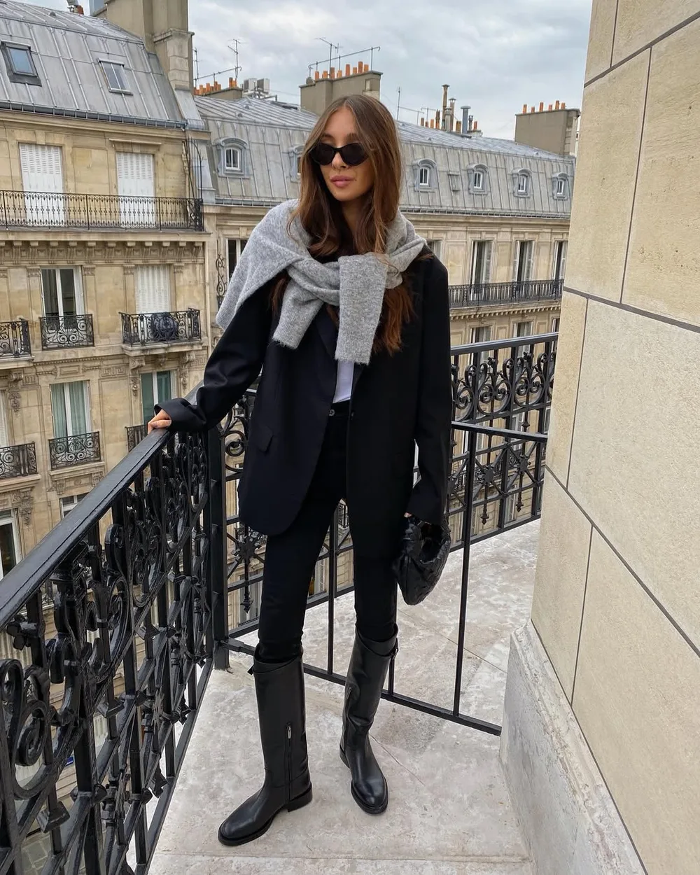 Blazer noir et jean slim portés avec des bottes cavalières