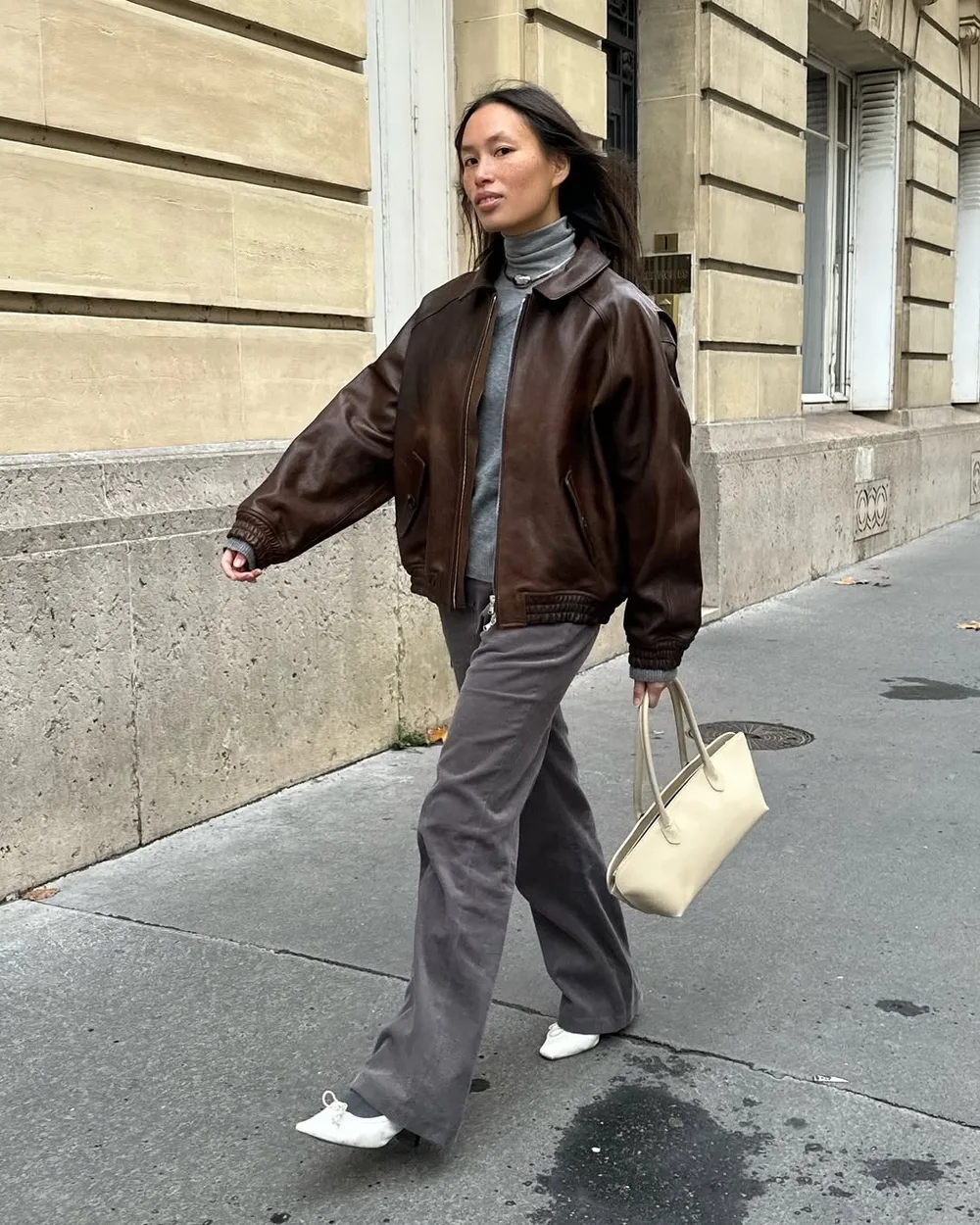 Bomber marron oversize avec pantalon gris et chaussures blanches