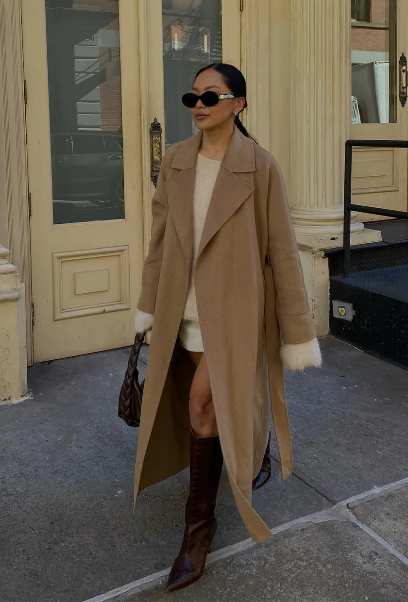 Bottes hautes chocolat, mini-jupe blanche et long manteau camel