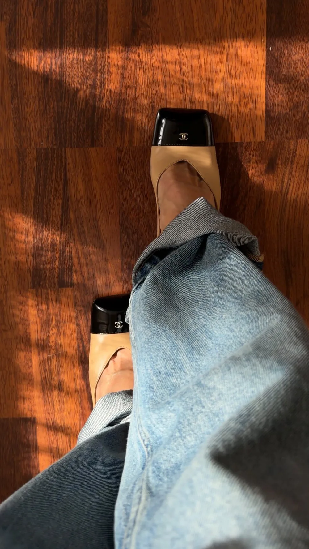 Chaussures bicolores à bout carré portées avec un jean par une femme mûre