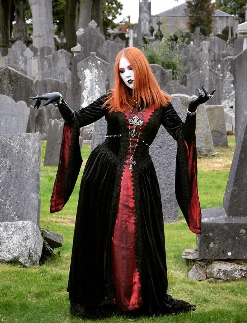 Comtesse vampire dans une longue robe noire et rouge en velours