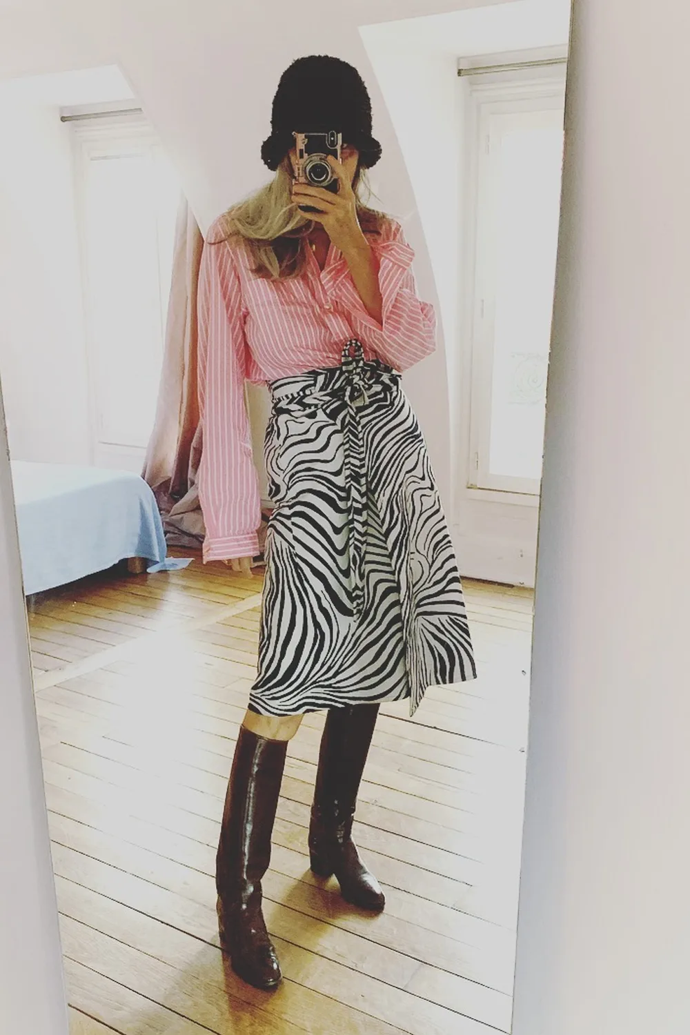 Femme de 60 ans en chemise rose et jupe zébrée élégante