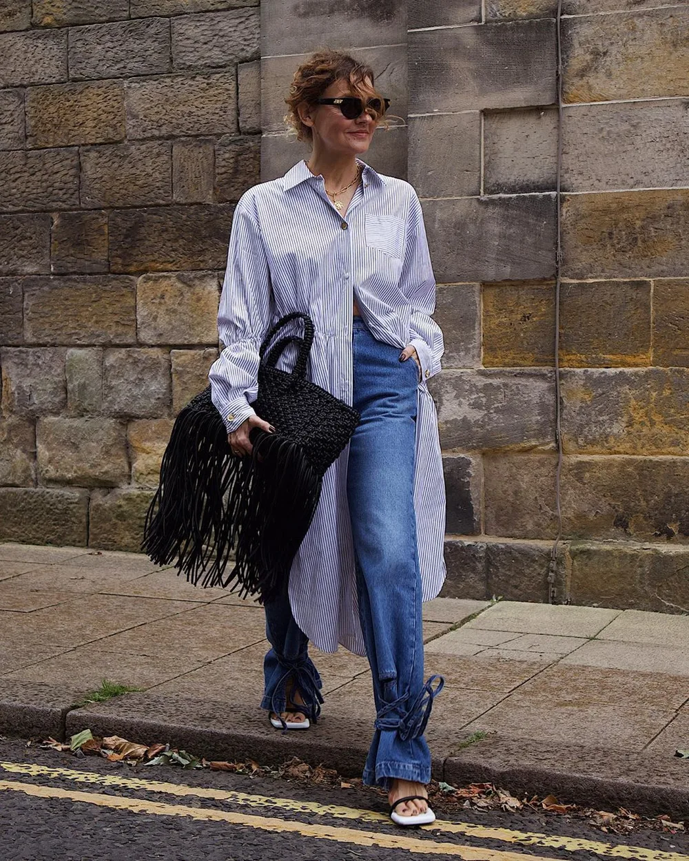 Femme de 60 ans en jean droit avec une chemise rayée oversize