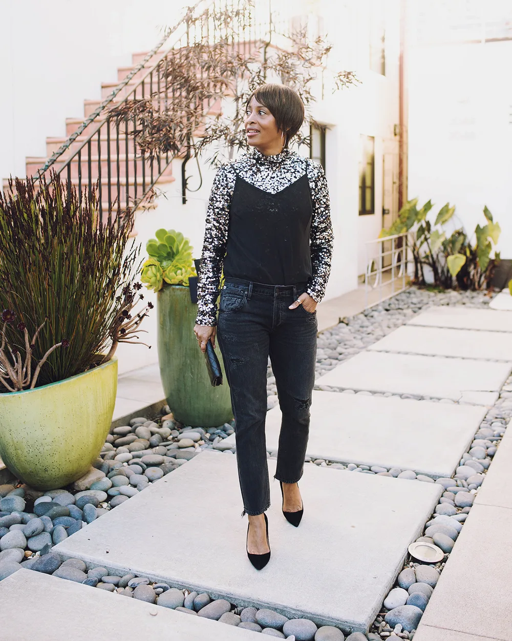 Femme de plus de 60 ans avec top bijou et pantalon noir élégant