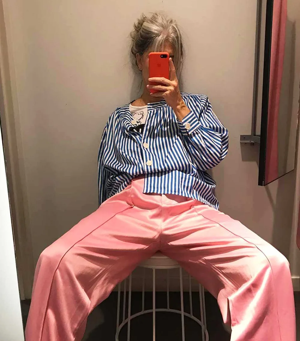 Femme de plus de 60 ans en chemise rayée et pantalon rose ample