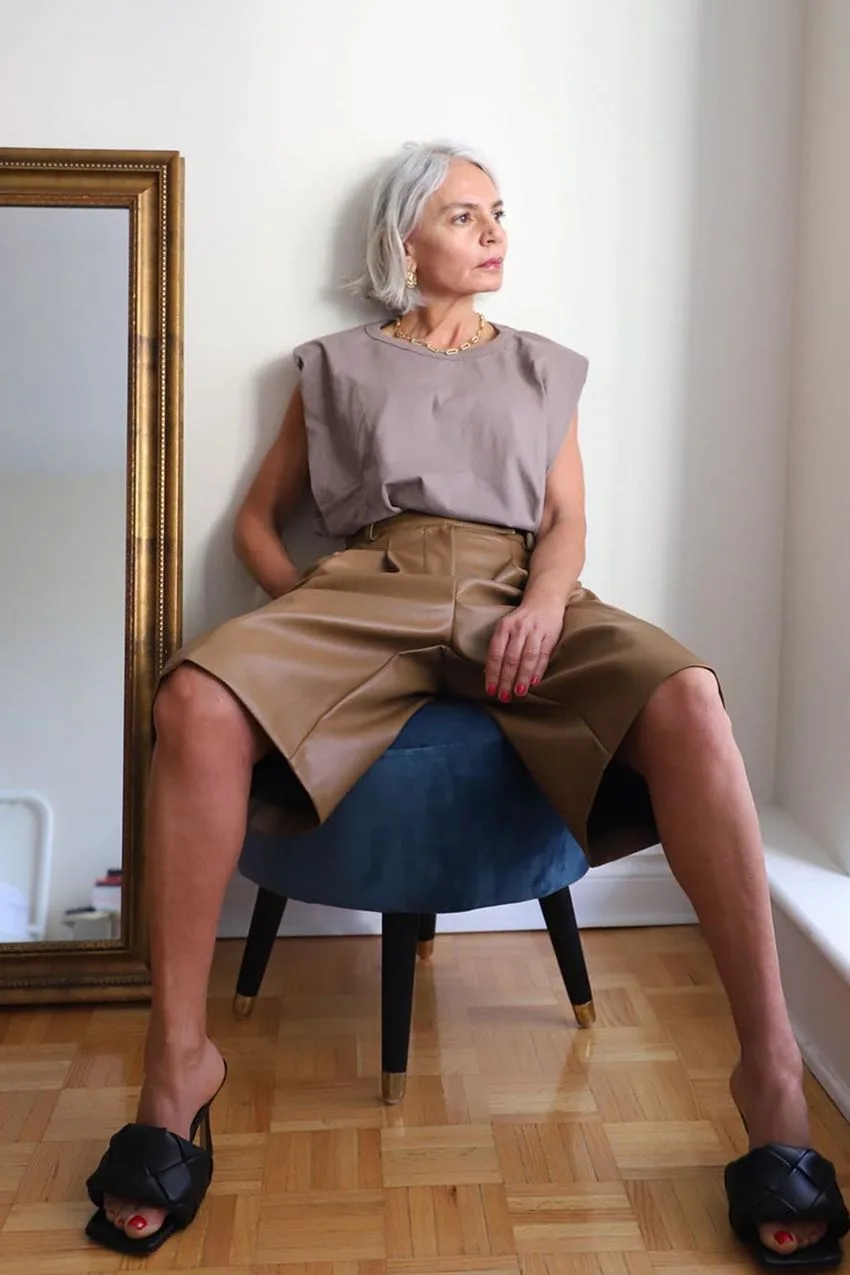 Femme de plus de 60 ans en top taupe sans manches et bermuda structuré