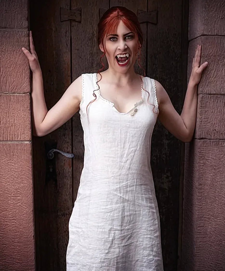 Femme déguisée en vampire victorien avec longue robe blanche