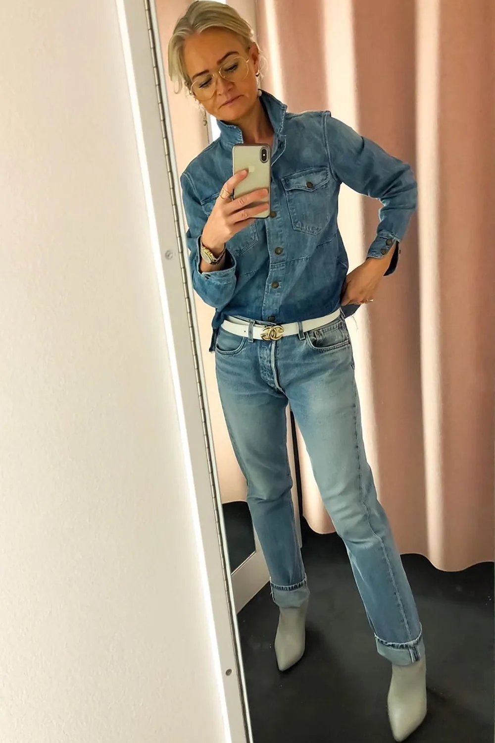 Femme mûre en chemise en jean et jean droit avec ceinture blanche