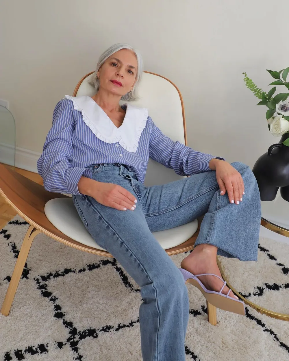 Femme mûre en jean large et blouse bleue à grand col blanc