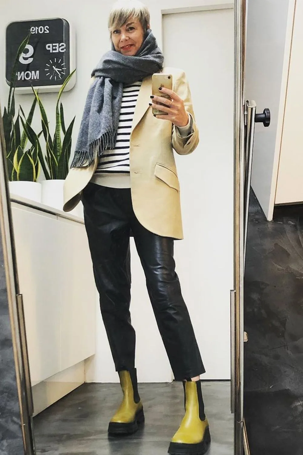 Femme mûre en marinière avec blazer beige, pantalon noir et bottines jaunes
