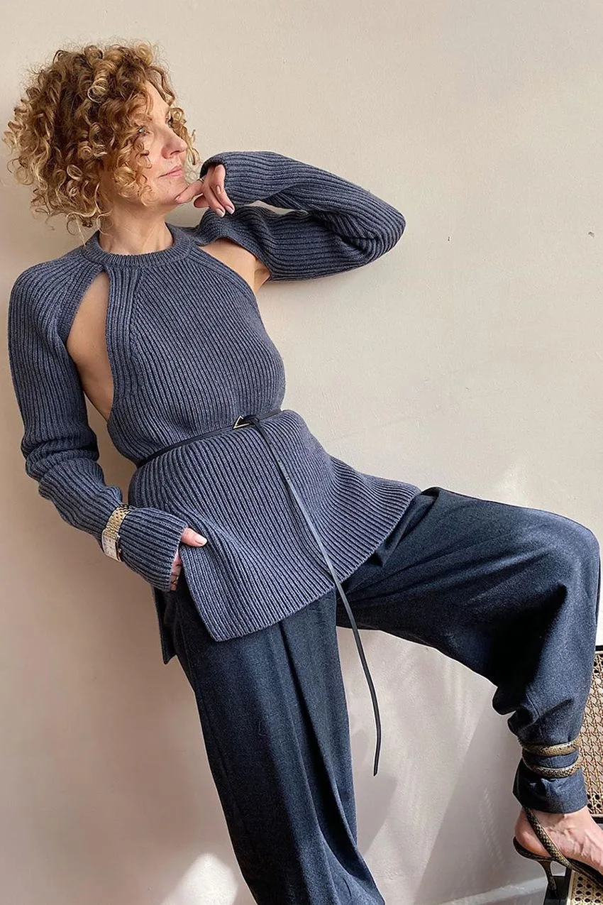 Femme mûre en pull gris asymétrique avec pantalon large assorti