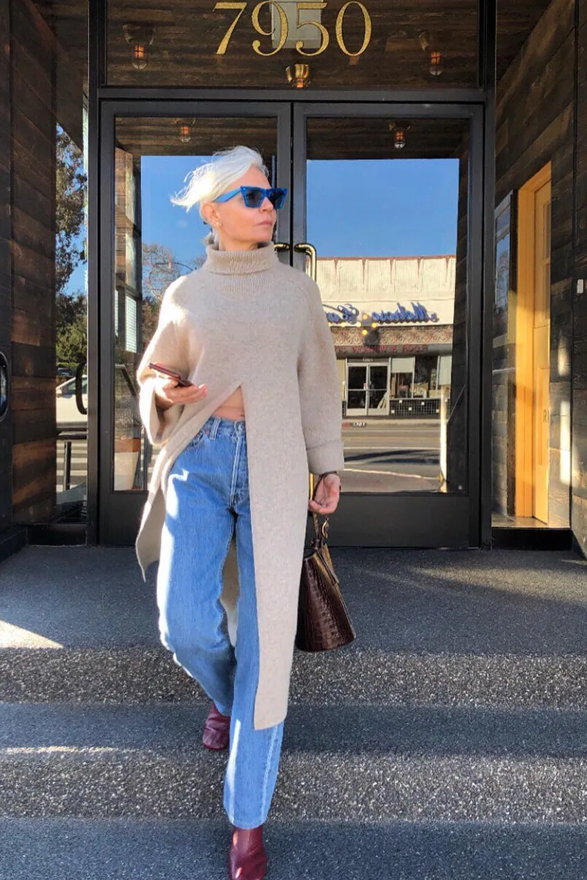 Femme mûre portant un poncho beige sable avec un jean bleu
