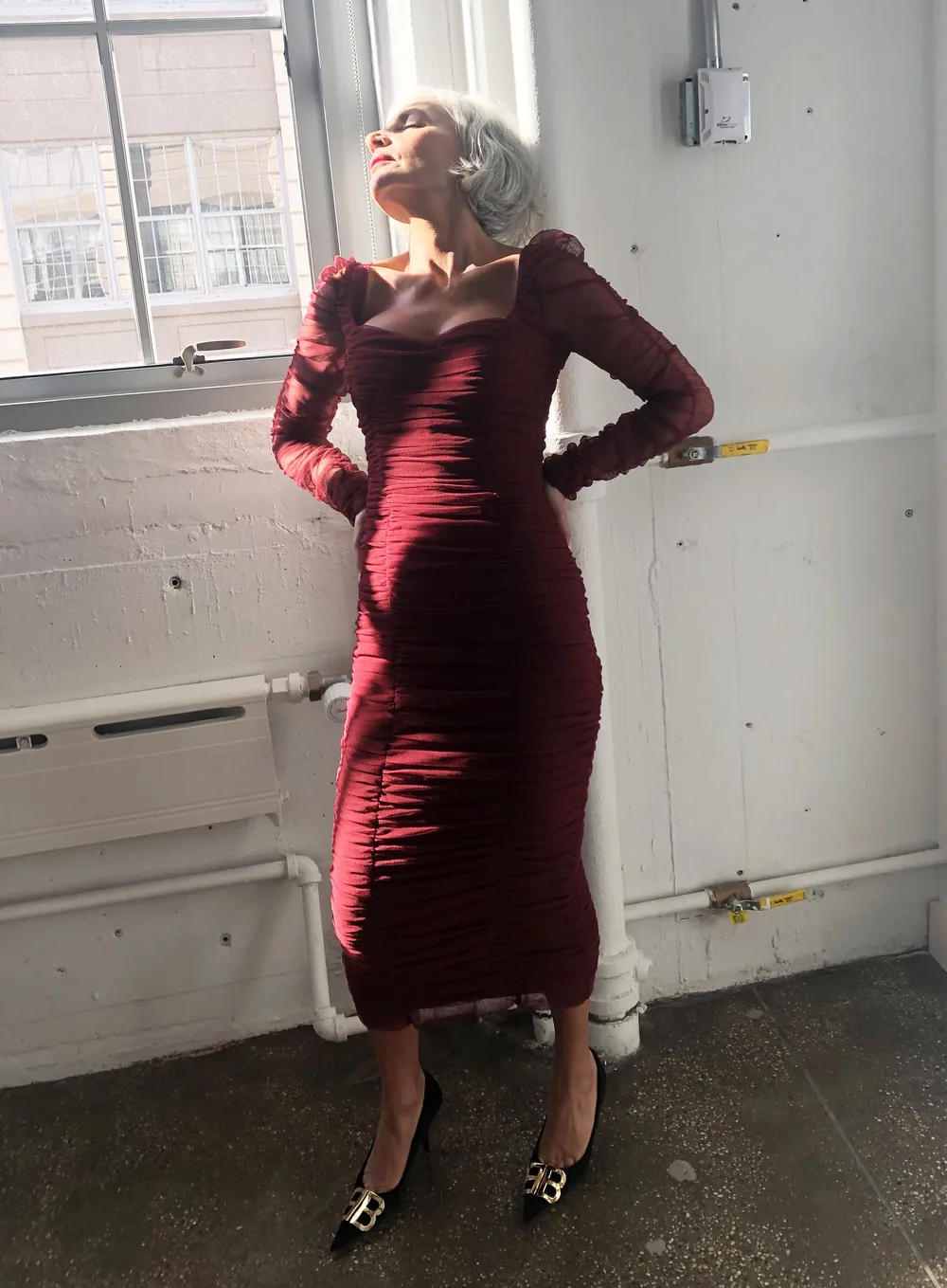 Femme mûre portant une robe bordeaux en velours pour le réveillon de Noël