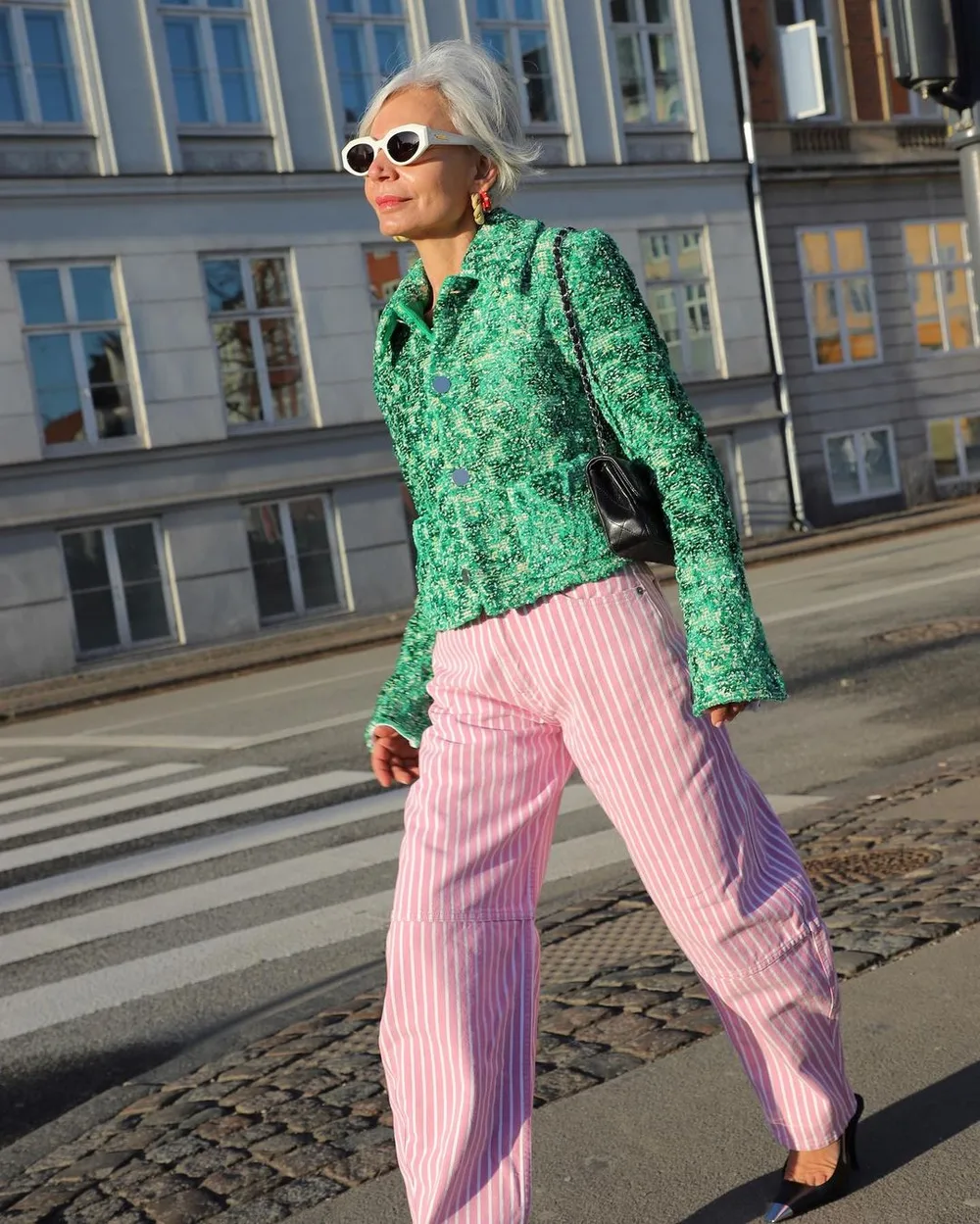 Femme mûre portant une veste vert émeraude avec un pantalon rose