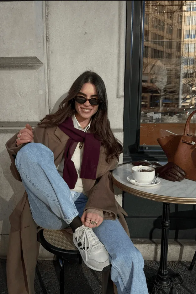 Jean bleu, veste marron et écharpe bordeaux pour un rendez-vous au café