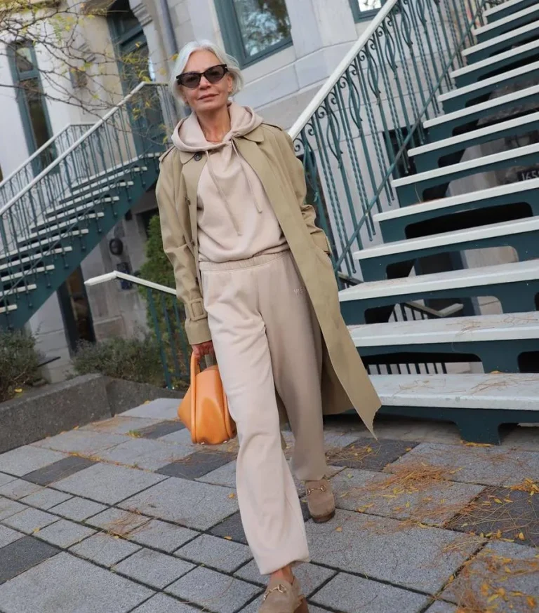 Jogging beige porté avec un trench long et des lunettes de soleil