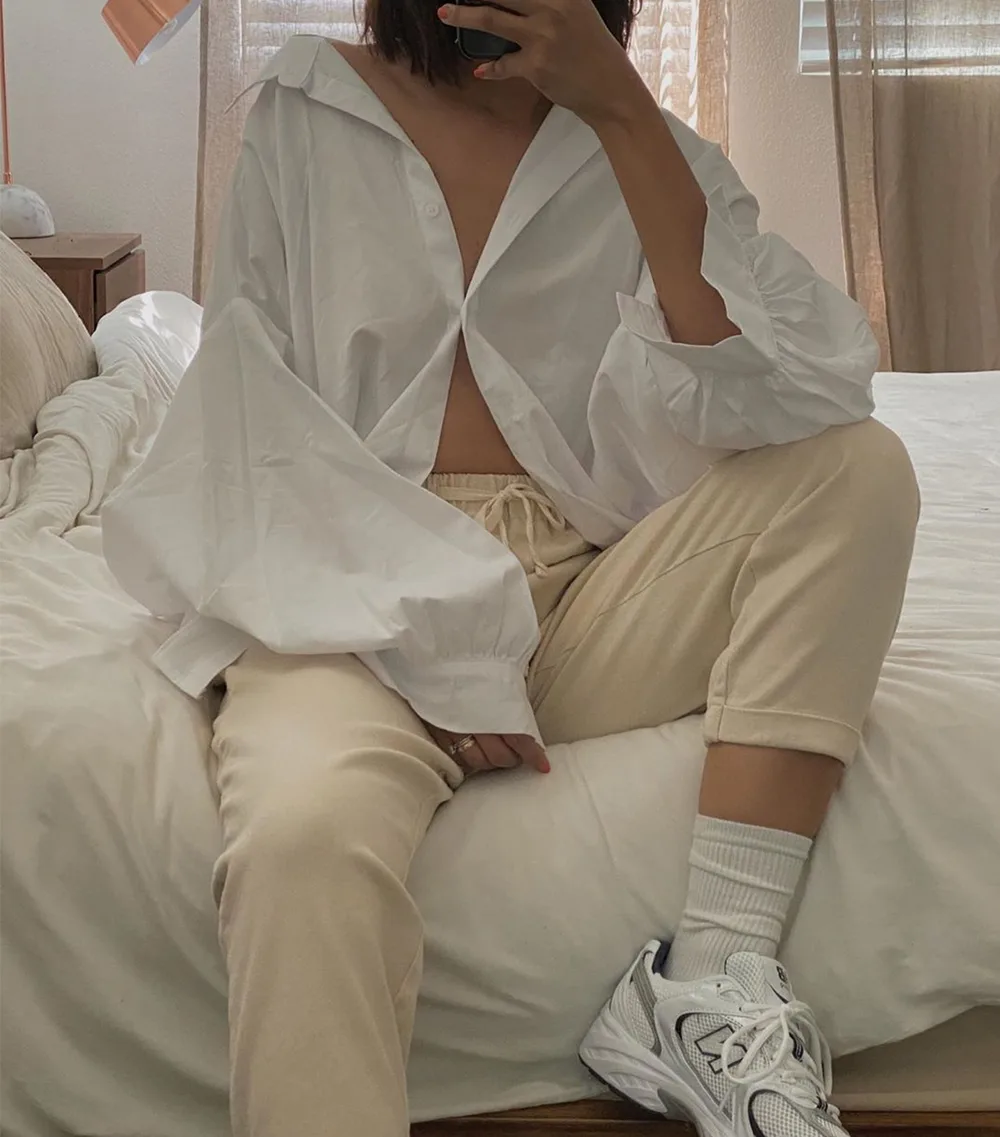 Jogging crème associé à une chemise blanche ample et des baskets