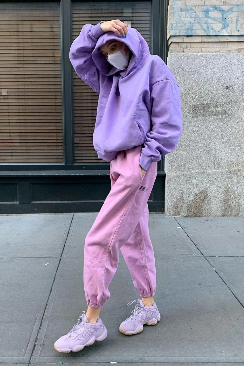 Jogging rose porté avec un sweat violet et des baskets assorties