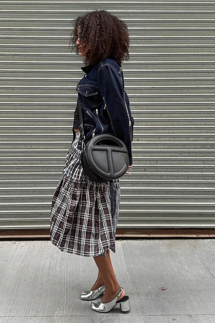 Jupe écossaise midi portée avec une veste en jean foncé