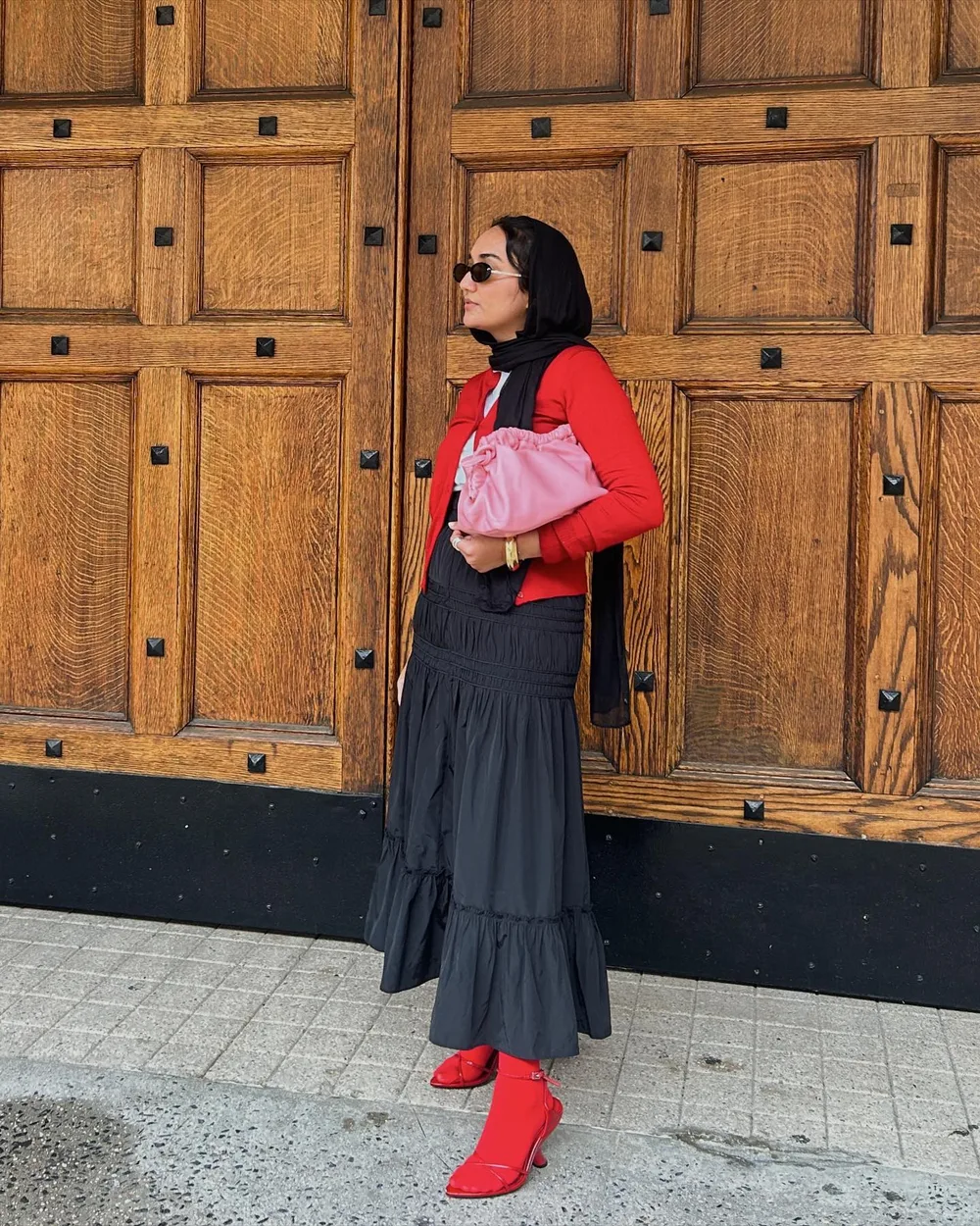 Maille rouge avec jupe longue sombre et sac rose