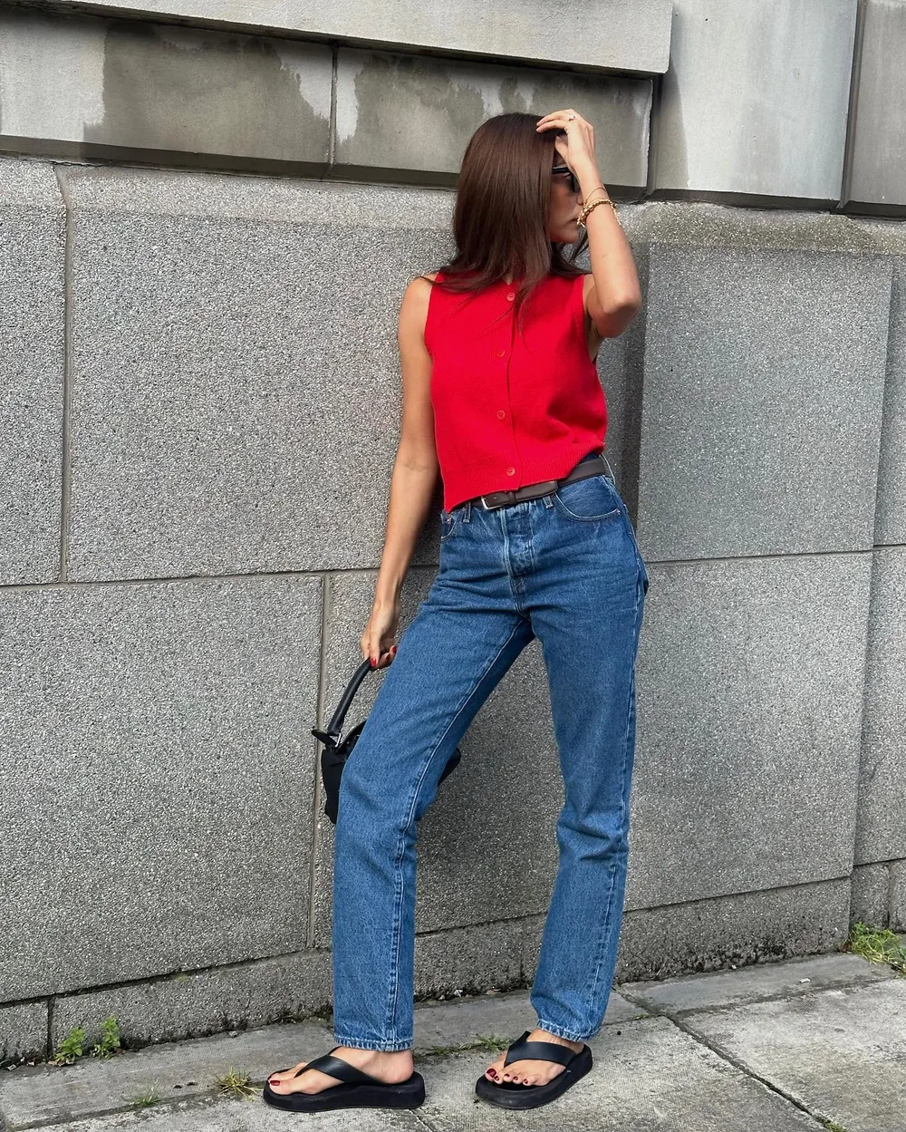 Maille rouge sans manches et jean bleu droit