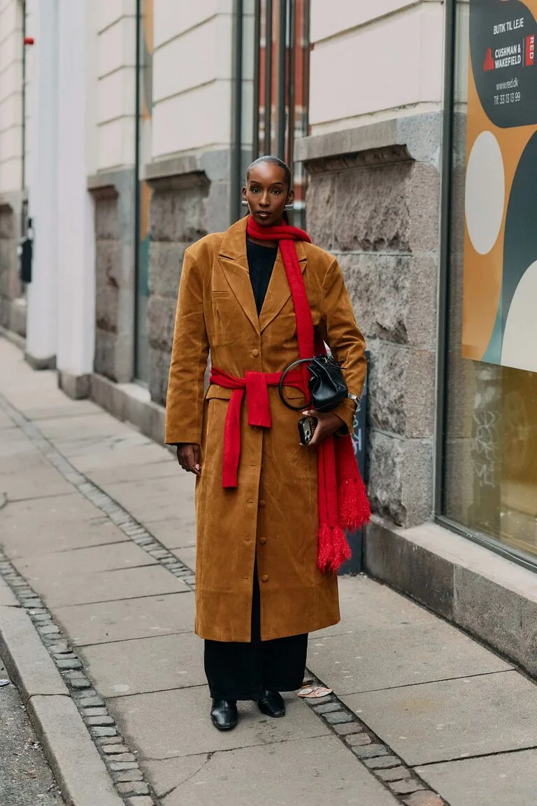 Manteau en daim caramel porté avec une écharpe rouge
