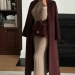 Manteau long bordeaux sur robe en maille beige et bottes marron