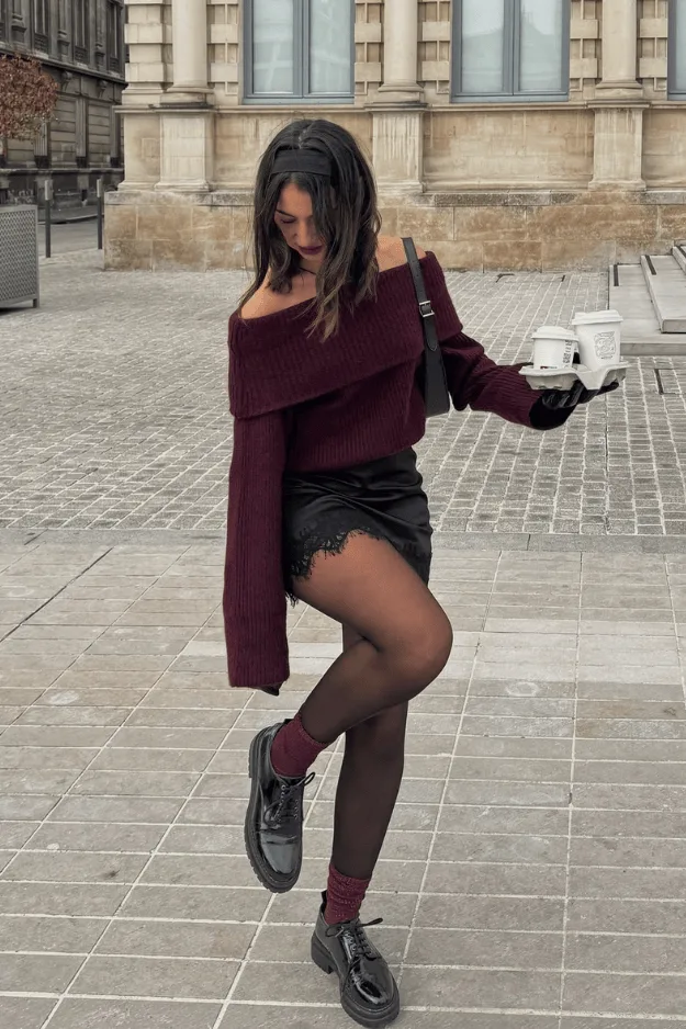 Pull bordeaux à épaules dégagées avec mini-jupe noire en dentelle et collants