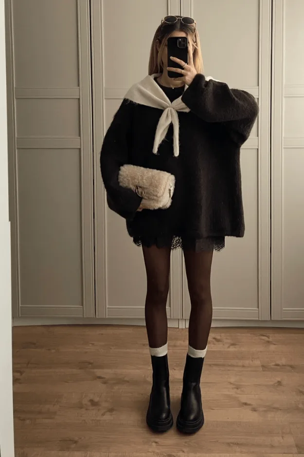 Pull noir à col noué crème avec jupe courte, collants et bottines