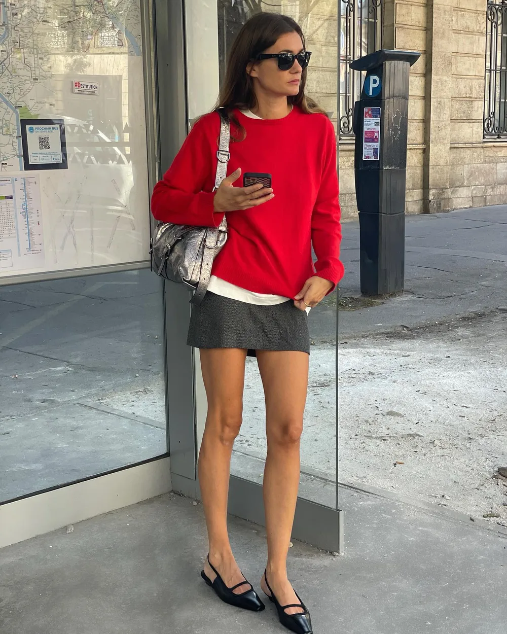 Pull rouge, mini-jupe grise et ballerines noires