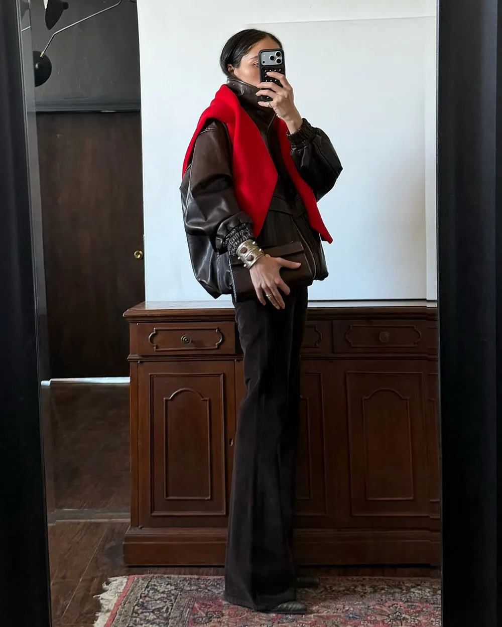 Pull rouge noué sur les épaules avec veste marron et pantalon sombre