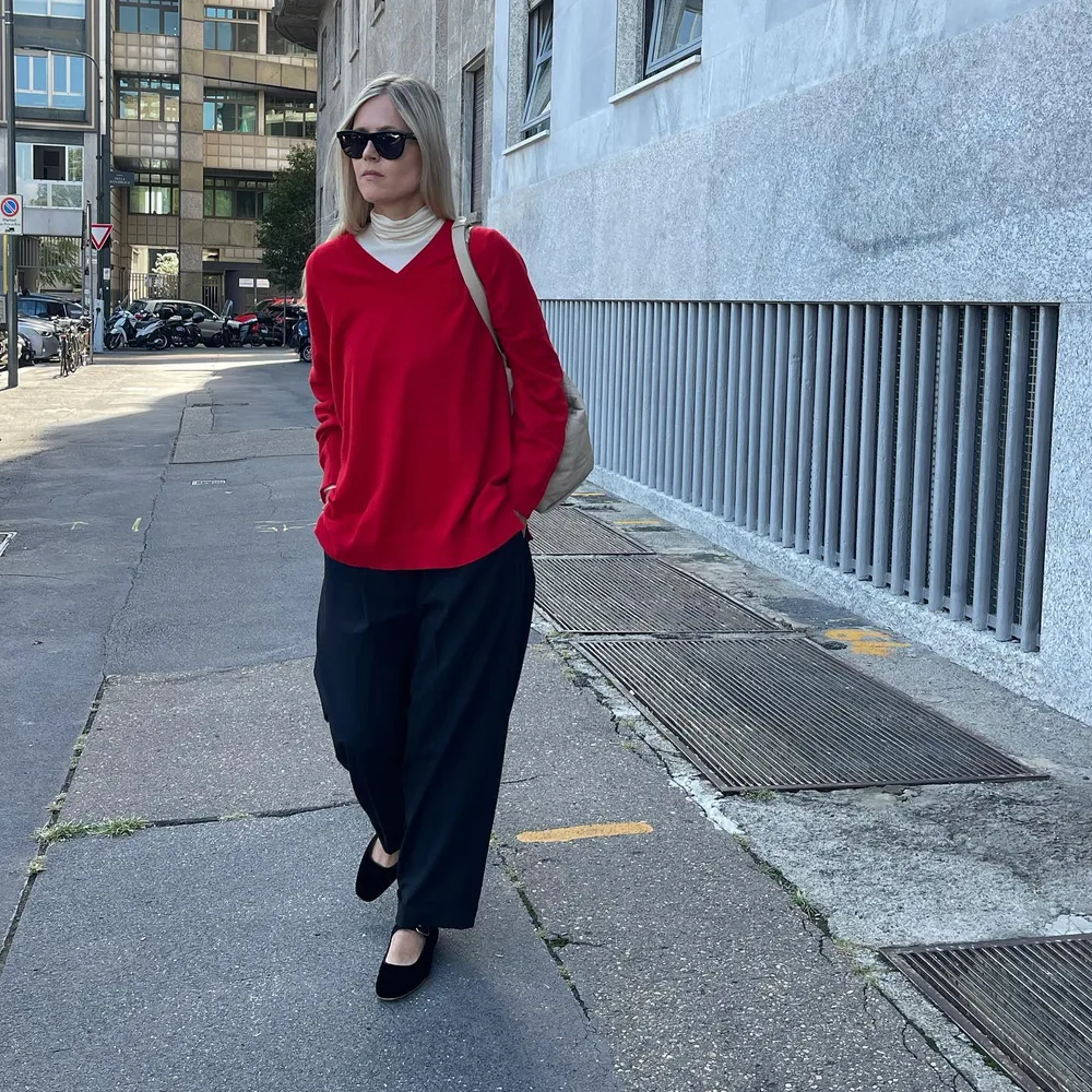 Pull rouge sur sous-pull fin avec pantalon sombre et ballerines