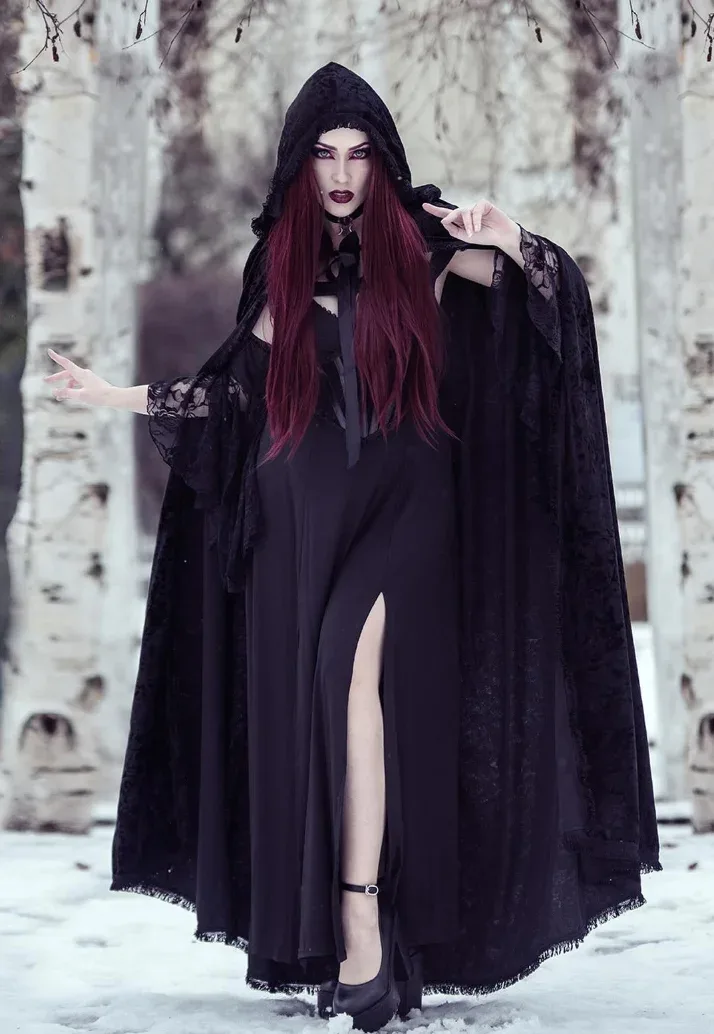 Reine vampire portant une longue cape noire dans la neige