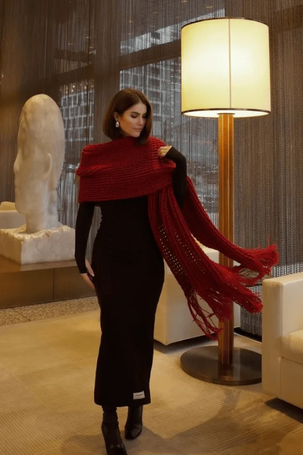 Robe longue noire portée avec une grande écharpe rouge et des escarpins