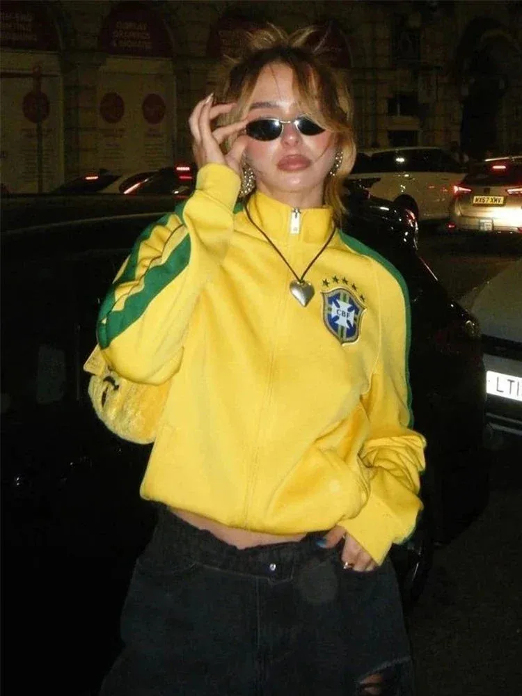 Veste Brésil jaune portée le soir avec un jean noir et des lunettes