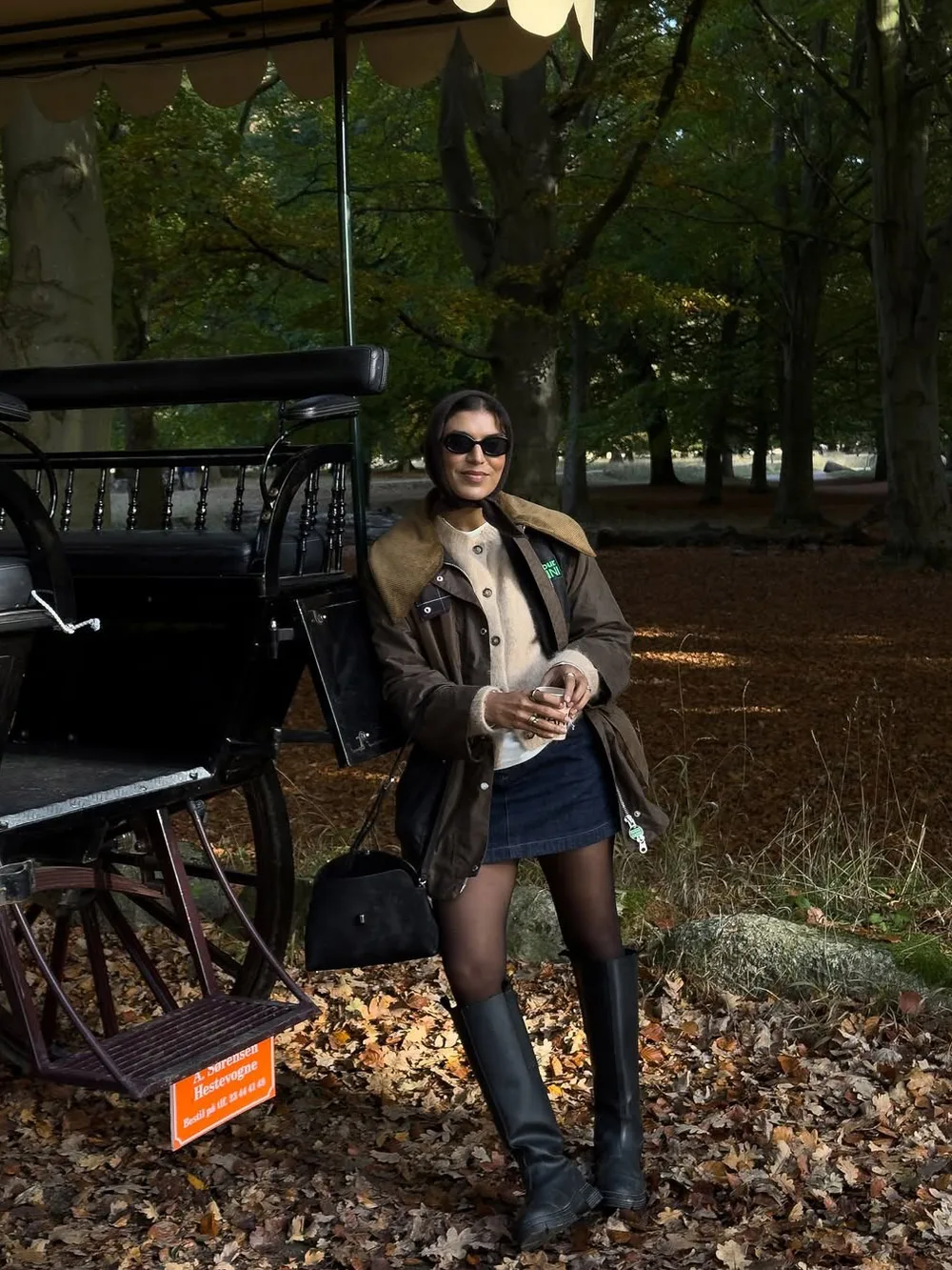 Veste courte marron portée avec une mini-jupe et des bottes hautes