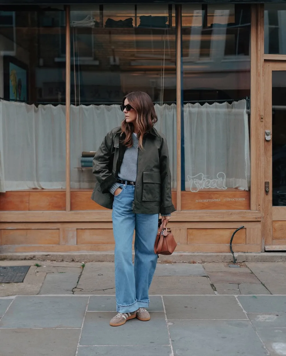 Veste kaki portée avec jean bleu, pull gris et baskets rétro