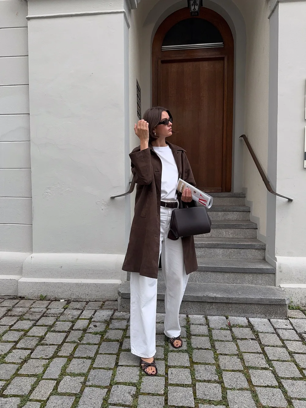 Veste longue marron avec tee-shirt et pantalon blancs