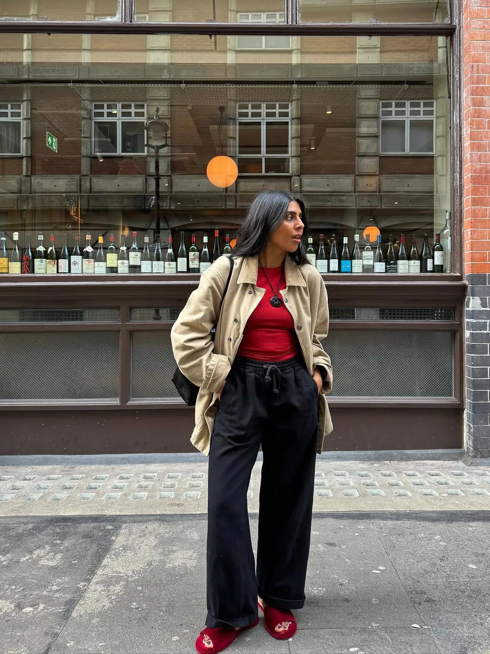 Veste sable avec pull rouge, pantalon noir et chaussures rouges
